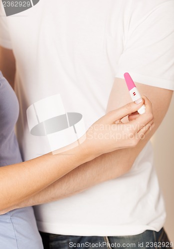 Image of woman and man hands with pregnancy test