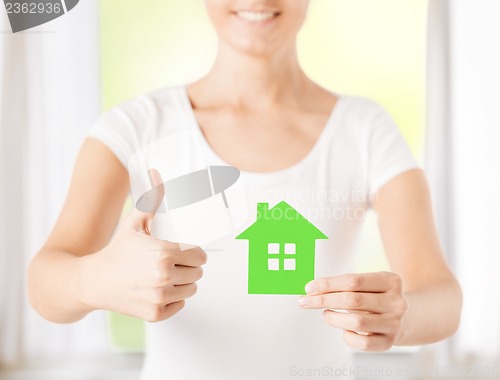 Image of woman hands holding green house