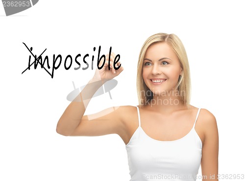 Image of woman writing the word (im)possible in the air
