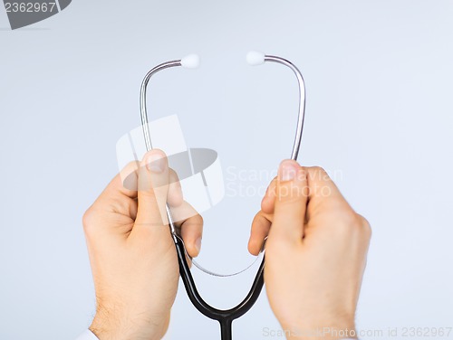 Image of doctor hand with stethoscope listening something