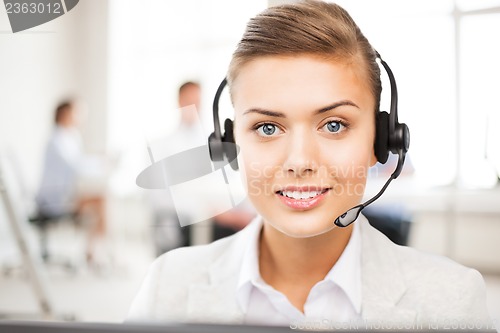 Image of helpline operator with headphones in call centre