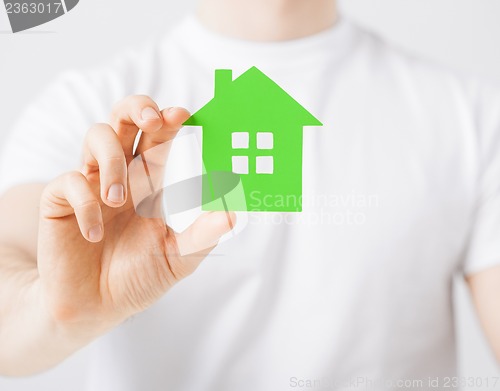 Image of hand holding green house