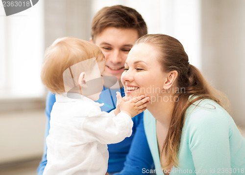 Image of happy parents playing with adorable baby