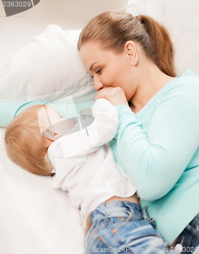 Image of mother and adorable baby with feeding-bottle