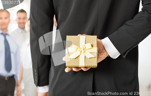 Image of man hands holding gift box in office