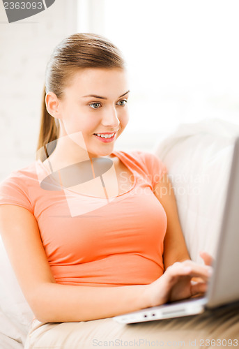 Image of happy woman using laptop at home