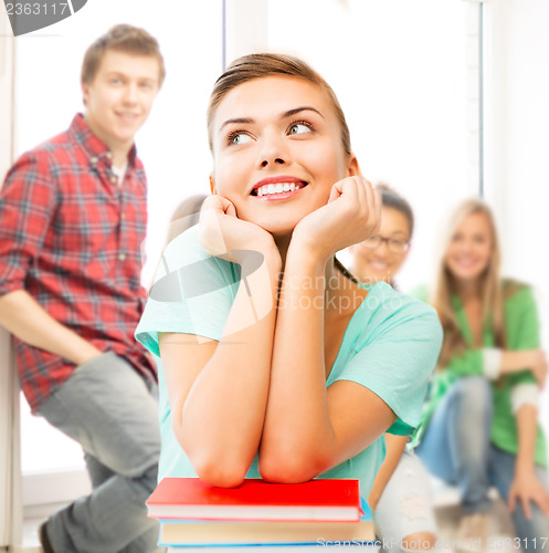 Image of happy smiling student girl with books at school