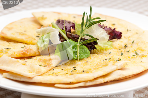 Image of garlic pita bread pizza with salad on top