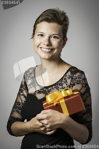 Image of Happy girl with evening dress and present