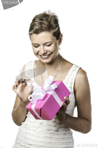 Image of Young pretty woman unwraps gift