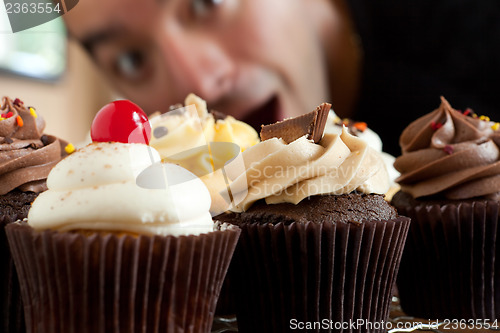 Image of Man Looks At Cupcakes