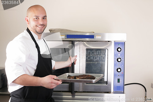 Image of Happy chef taking his freshly baked rib-eye steak