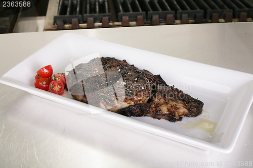 Image of Rib-eye steak resting on the plate in the kitchen ready to serve