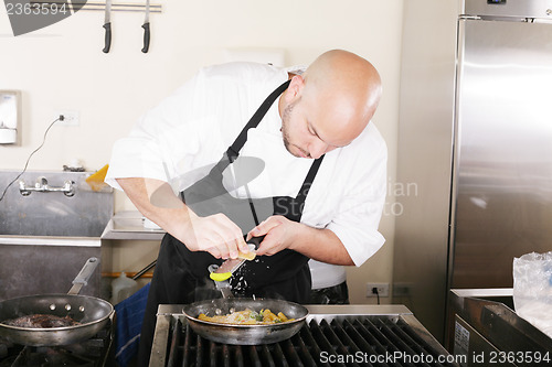 Image of Chef putting grated parmesan to an italian pasta