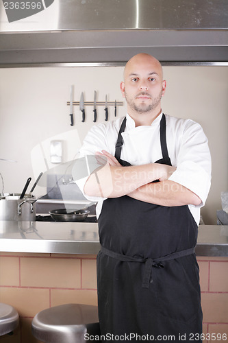 Image of Male Chef Standing Next To Cooker In Kitchen