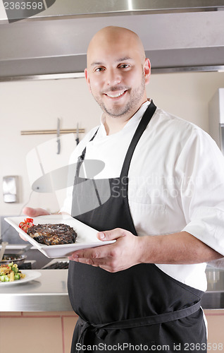 Image of Chef presenting a juicy steak in the kitchen