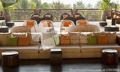 Image of cafe with sofas and cushions, palm