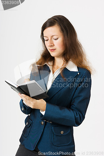 Image of A young girl with a notebook writing