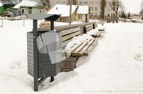 Image of town bench waste bin cover snow house winter 