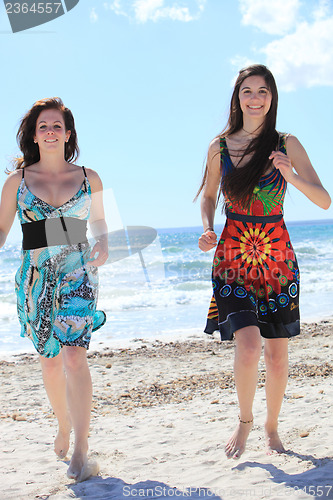 Image of Two attractive barefoot women on the beach
