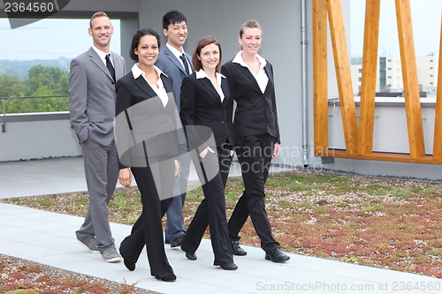 Image of Stylish young business team walking together