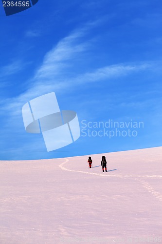 Image of Two hikers on sunrise snow plateau