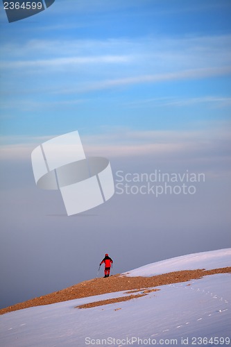 Image of Hiker on edge of cliff in sunrise