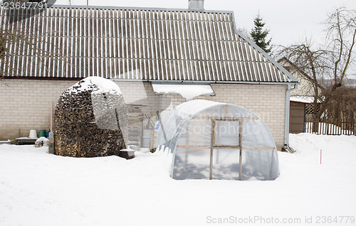 Image of stack firewood polythene greenhouse snow winter 