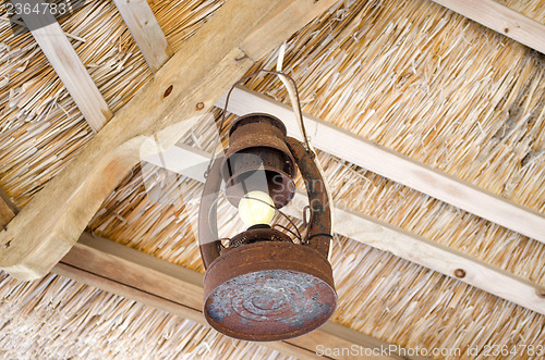 Image of old rusty lamp  bower straw ceiling electric bulb 