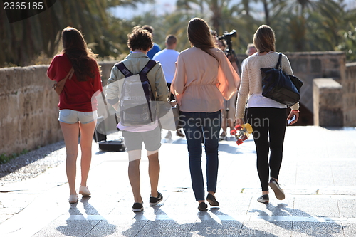 Image of Rear view of four students walking away