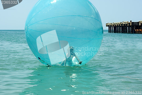 Image of Little girl inside a giant balloon on the sea surface