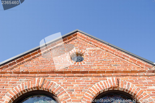 Image of round window arch retro brick house roof blue sky 