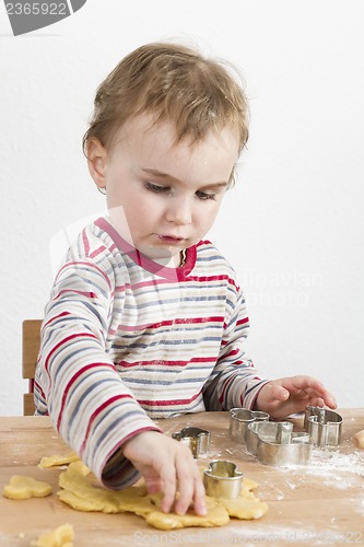 Image of child working with dough on wooden desk