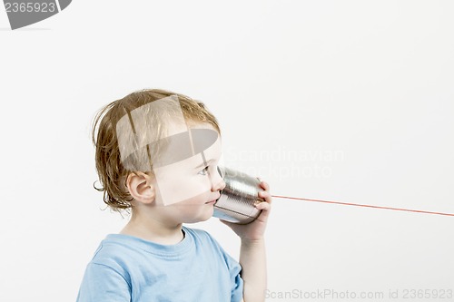 Image of young child with tin can phone