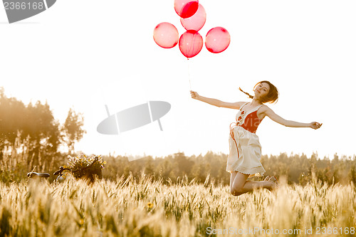 Image of Girl jumping with balloons