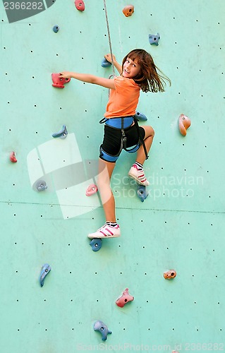 Image of smiling child climbing up the wall