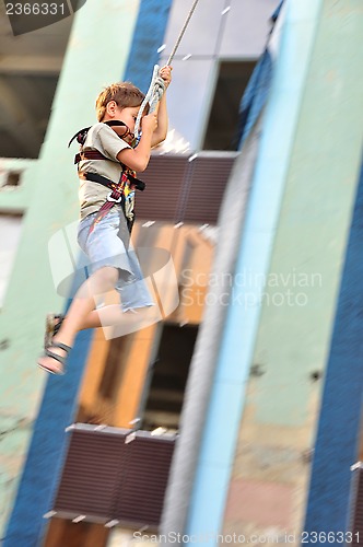 Image of child sliding down in the urban scene