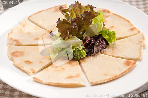 Image of garlic pita bread pizza with salad on top