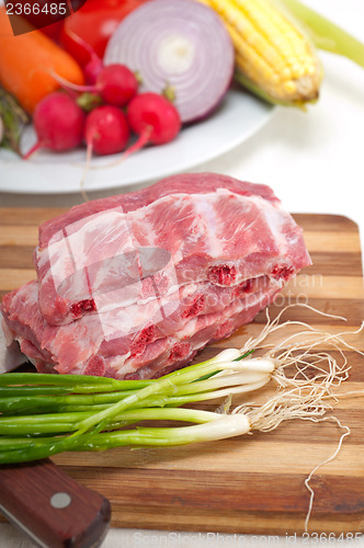 Image of chopping fresh pork ribs and vegetables