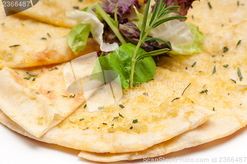 Image of garlic pita bread pizza with salad on top