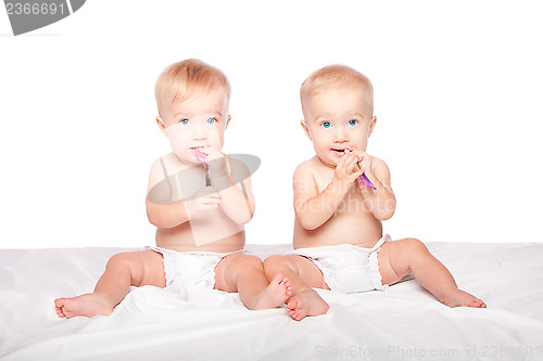 Image of Cute twins babies with spoons