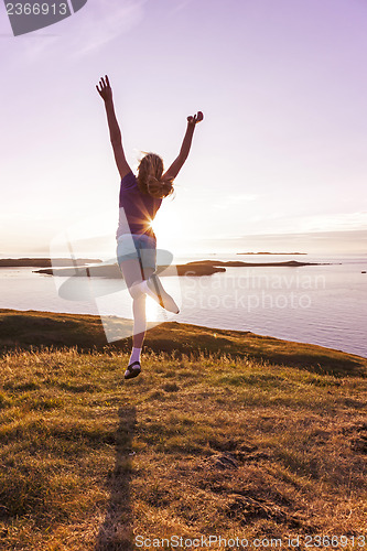 Image of Teenage girl dancing in the sunset