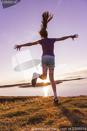 Image of Teenage girl dancing in the sunset