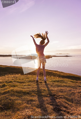 Image of Teenage girl dancing in the sunset