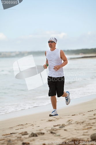 Image of man is jogging on the beach summertime sport fitness