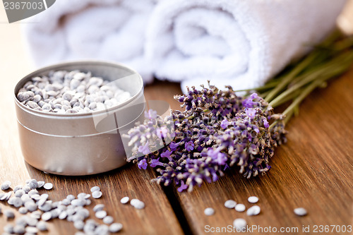 Image of fresh lavender white towel and bath salt on wooden background