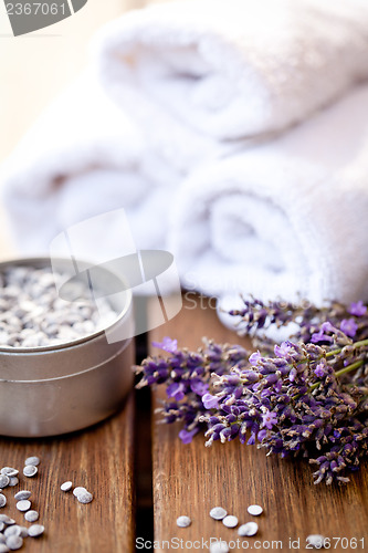 Image of fresh lavender white towel and bath salt on wooden background