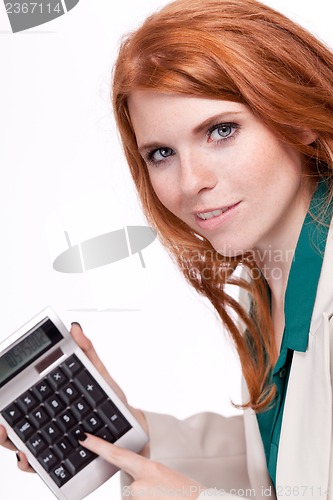 Image of attractive smiling redhead business woman with calculator isolated