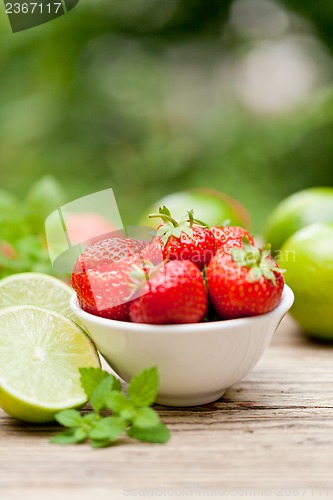 Image of fresh tasty sweet strawberries and green lime outdoor in summer