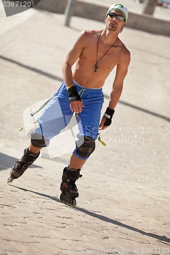 Image of young man with inline skates in summer outdoor 